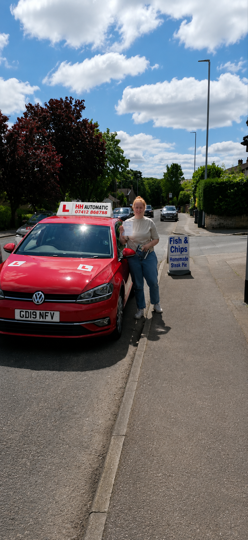 Learner beside red driving school car